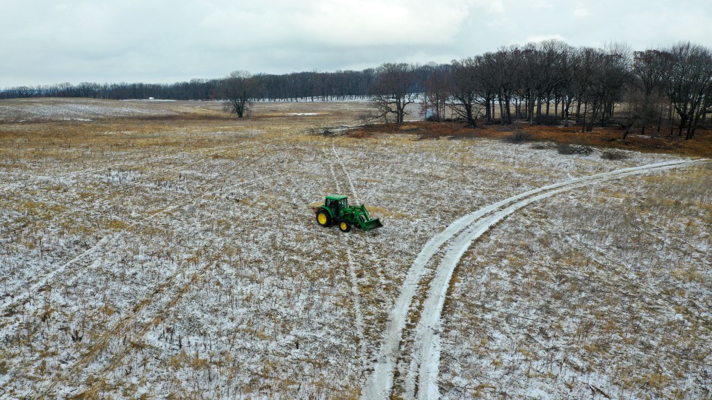 A tractor spreads native seed in a former farm field. Photo © Mike Borkowski.