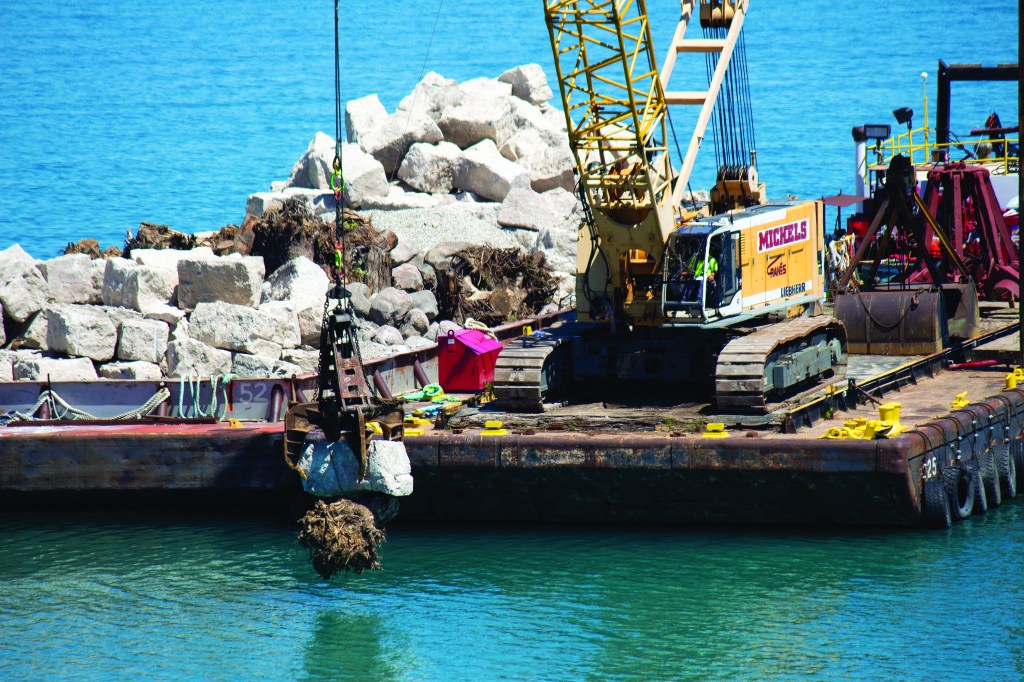 Crews used a crane mounted on a barge to lower boulders, limestone slabs and other materials onto the lakebed.